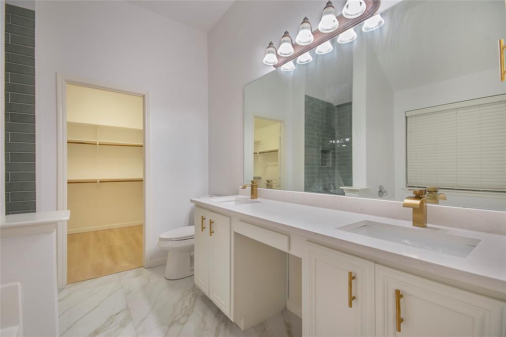 549 Hickory Lane Fate, TX 75087 - Photo 14 of 22 a bathroom with a sink a toilet and a mirror