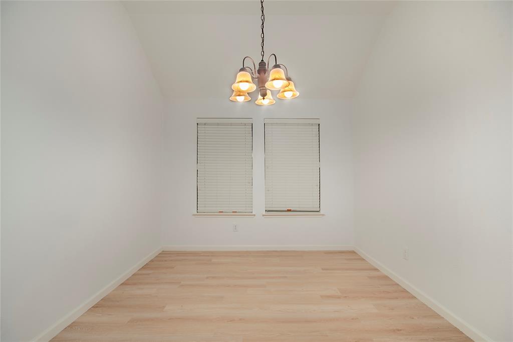 549 Hickory Lane Fate, TX 75087 - Photo 5 of 22 Unfurnished dining area with lofted ceiling, light wood-style floors, and a chandelier