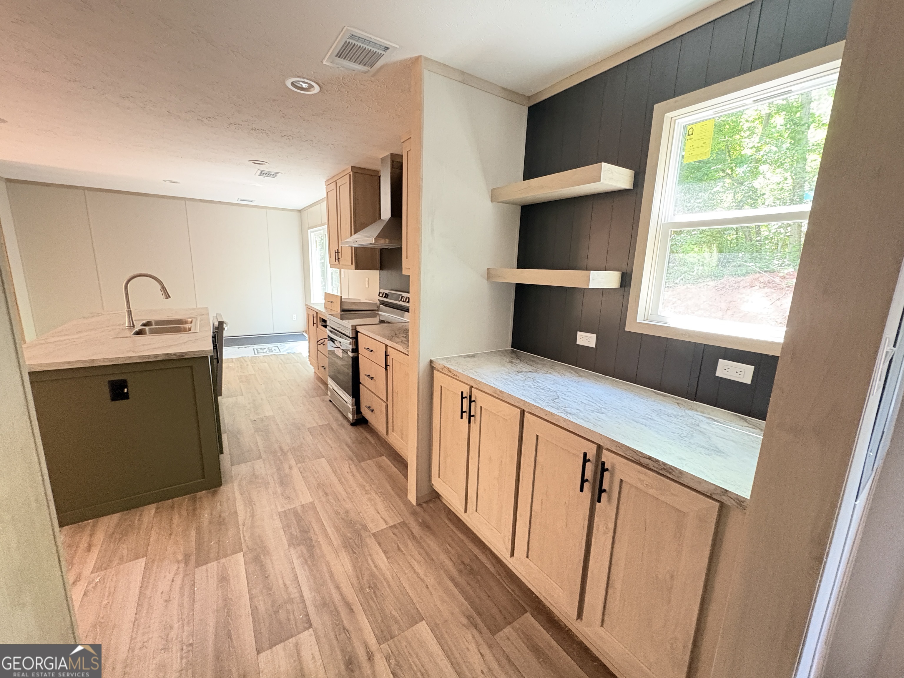 1020 Neal Road Commerce, GA 30530 - Photo 3 of 25 a kitchen with kitchen island wooden floors appliances a sink and a counter top space