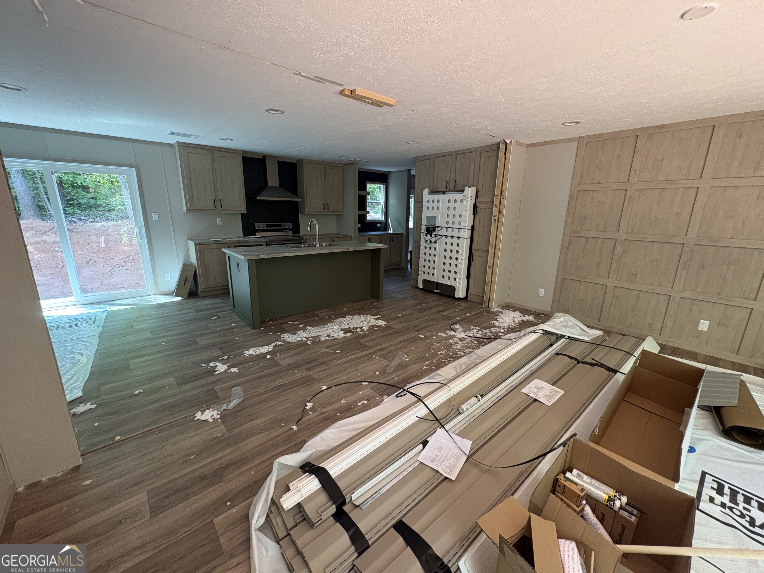 1020 Neal Road Commerce, GA 30530 - Photo 4 of 25 a view of a kitchen with kitchen island a sink wooden floor and a counter top space