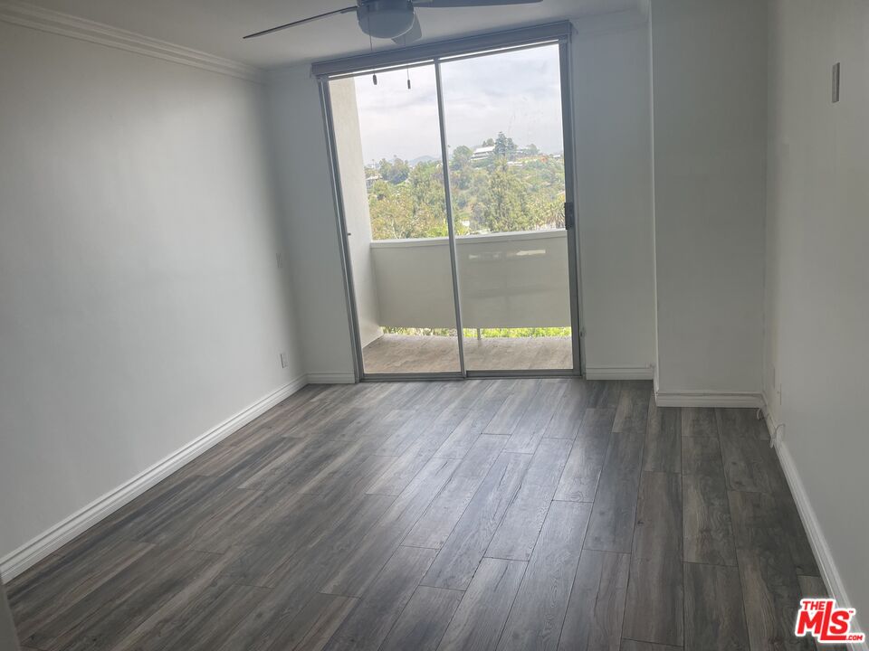 7250 Franklin Avenue, Unit 702 Los Angeles, CA 90046 - Photo 26 of 39 an empty room with wooden floor and windows
