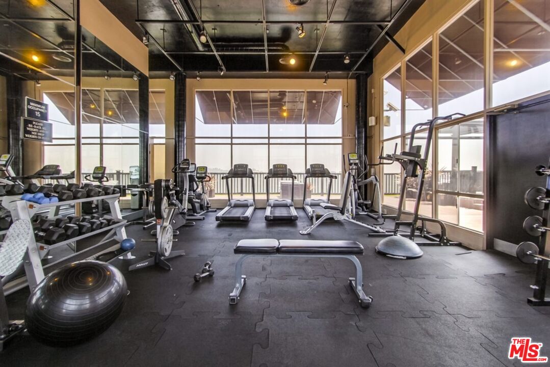 7250 Franklin Avenue, Unit 702 Los Angeles, CA 90046 - Photo 5 of 39 a room with gym equipment and floor to ceiling window