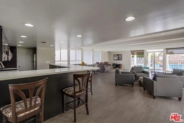 a living room with furniture a flat screen tv and kitchen view