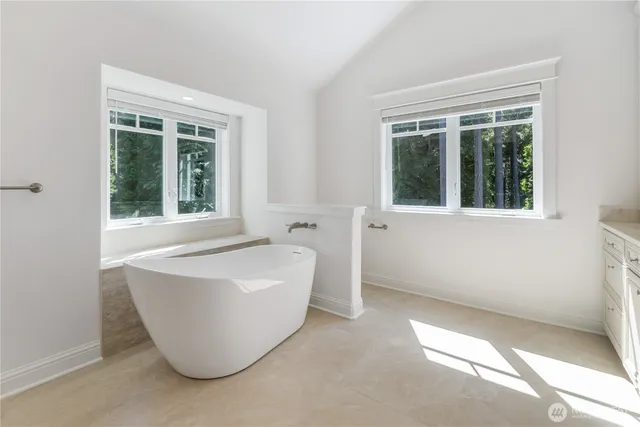 a white bath tub sitting in front of a window