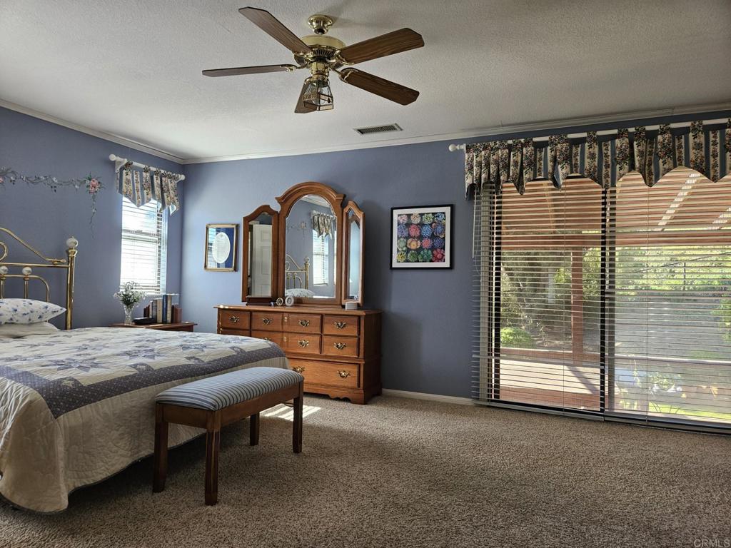 28124 Mountain Meadow Road Escondido, CA 92026 - Photo 15 of 31 a bed room with a bed and a chandelier