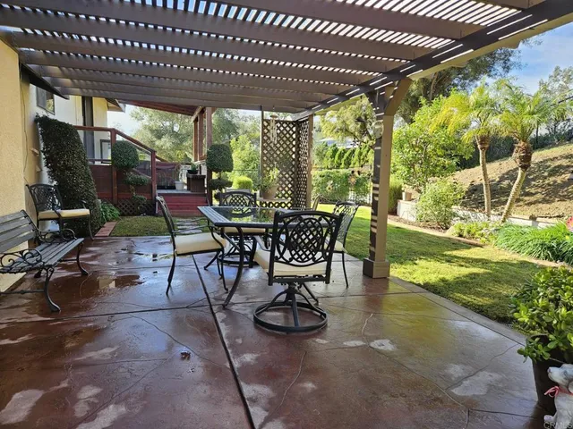 a view of a patio with table and chairs potted plants and large tree
