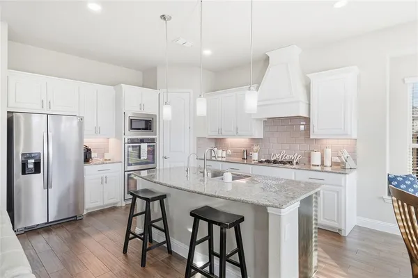 a kitchen with sink stove and cabinets
