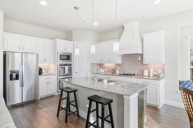 a kitchen with sink stove and cabinets