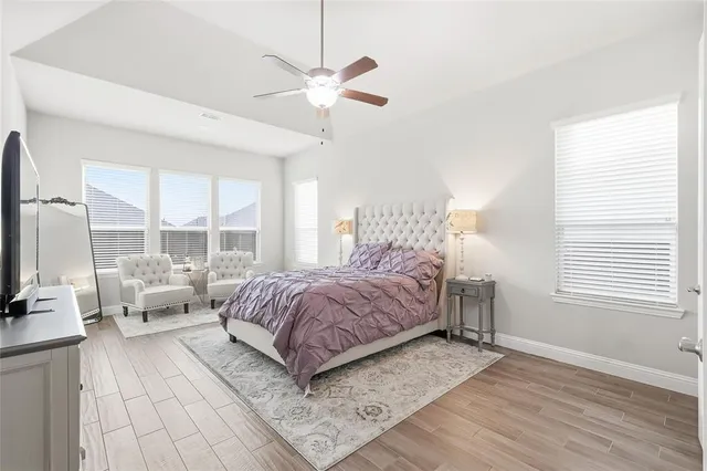 a spacious bedroom with a bed and a flat screen tv