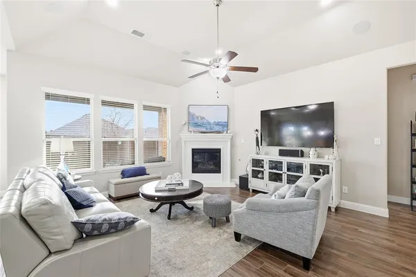 a living room with furniture kitchen view and a chandelier