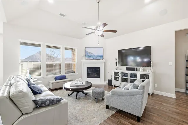 a living room with furniture kitchen view and a chandelier