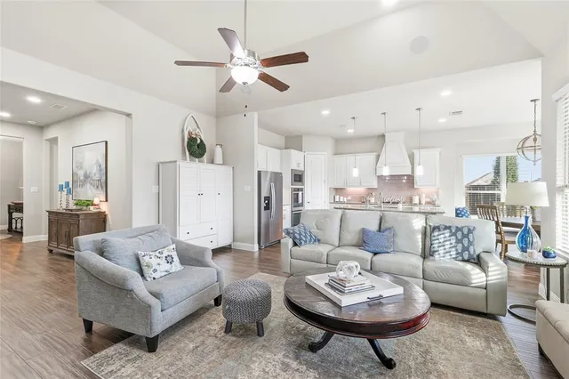 a kitchen with stainless steel appliances granite countertop a table chairs sink and cabinets