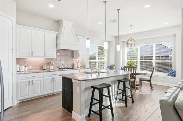 a kitchen with stainless steel appliances a stove a sink a refrigerator and a refrigerator