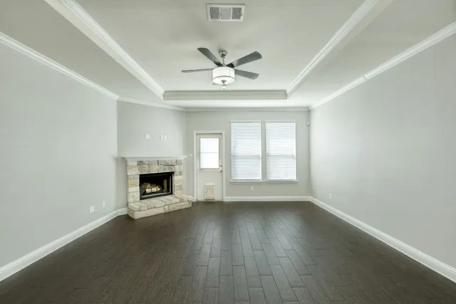 an empty room with windows and a fireplace