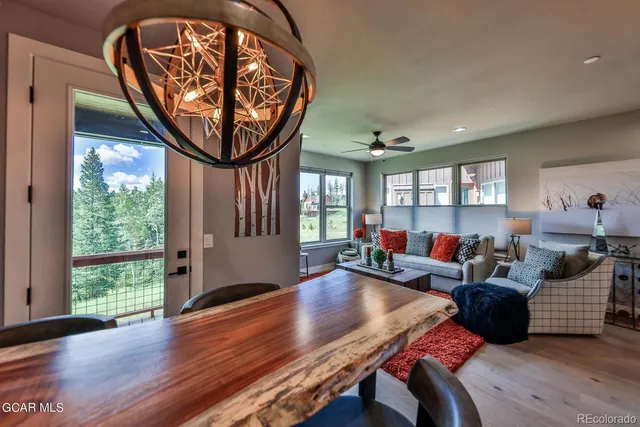 a living room with furniture a large window and wooden floor