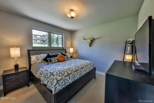 a bedroom with bed cabinet and window