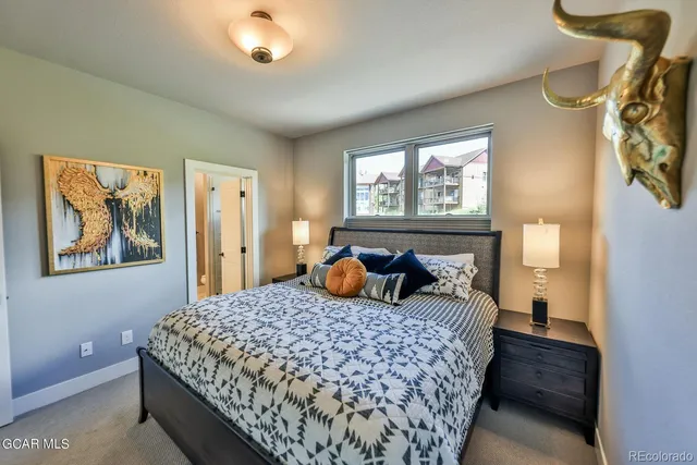 a bedroom with a bed and a painting on the wall