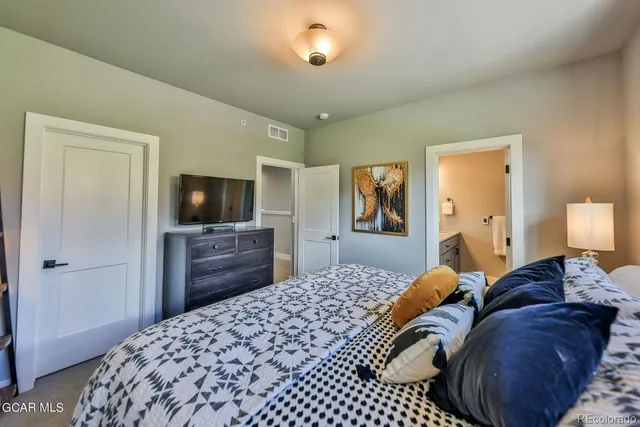 a bedroom with a bed and a flat screen tv