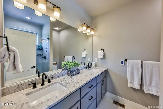 a bathroom with a granite countertop sink and a mirror