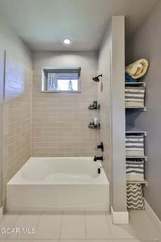 a bathroom with bathtub and window