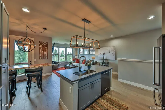 a kitchen with a sink a counter and chairs