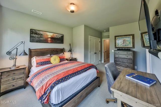 a bedroom with a bed and a flat screen tv