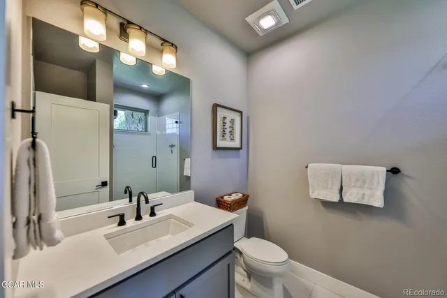 a bathroom with a sink vanity mirror and toilet