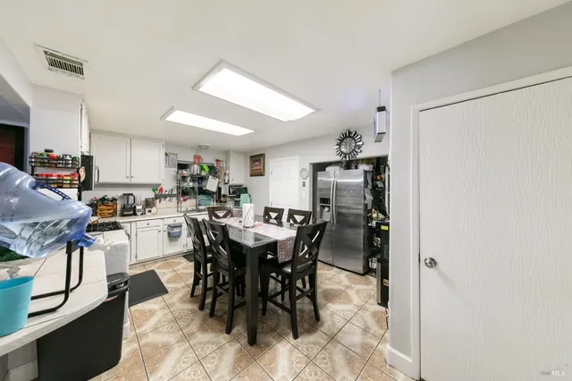 a view of a dining room with furniture and a kitchen