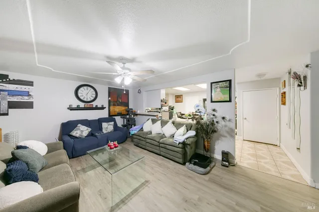 a living room with furniture a rug and white walls