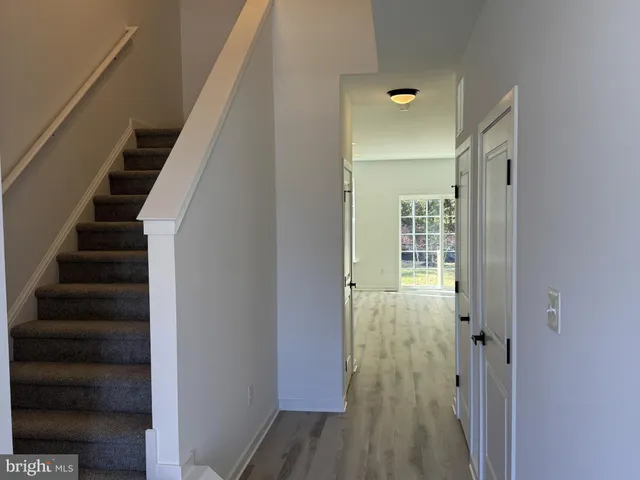 a view of a hallway with wooden floor and entryway