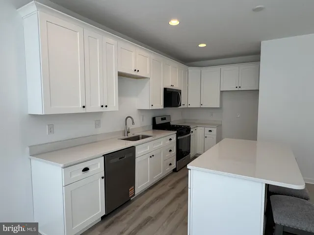 a kitchen with a sink a stove a refrigerator and cabinets