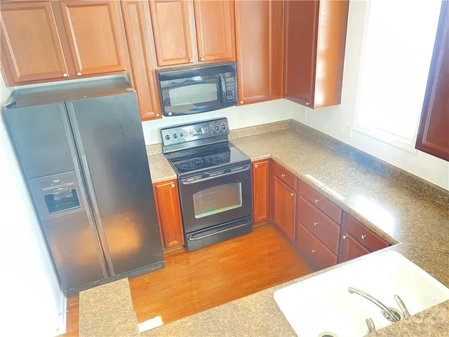 a kitchen with a sink a stove and a microwave