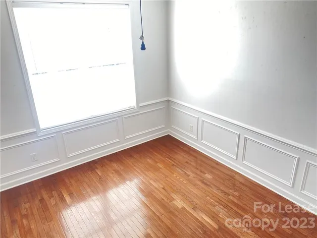 a view of a small space with wooden floor and a window