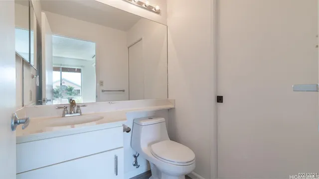 a bathroom with a toilet sink vanity and mirror