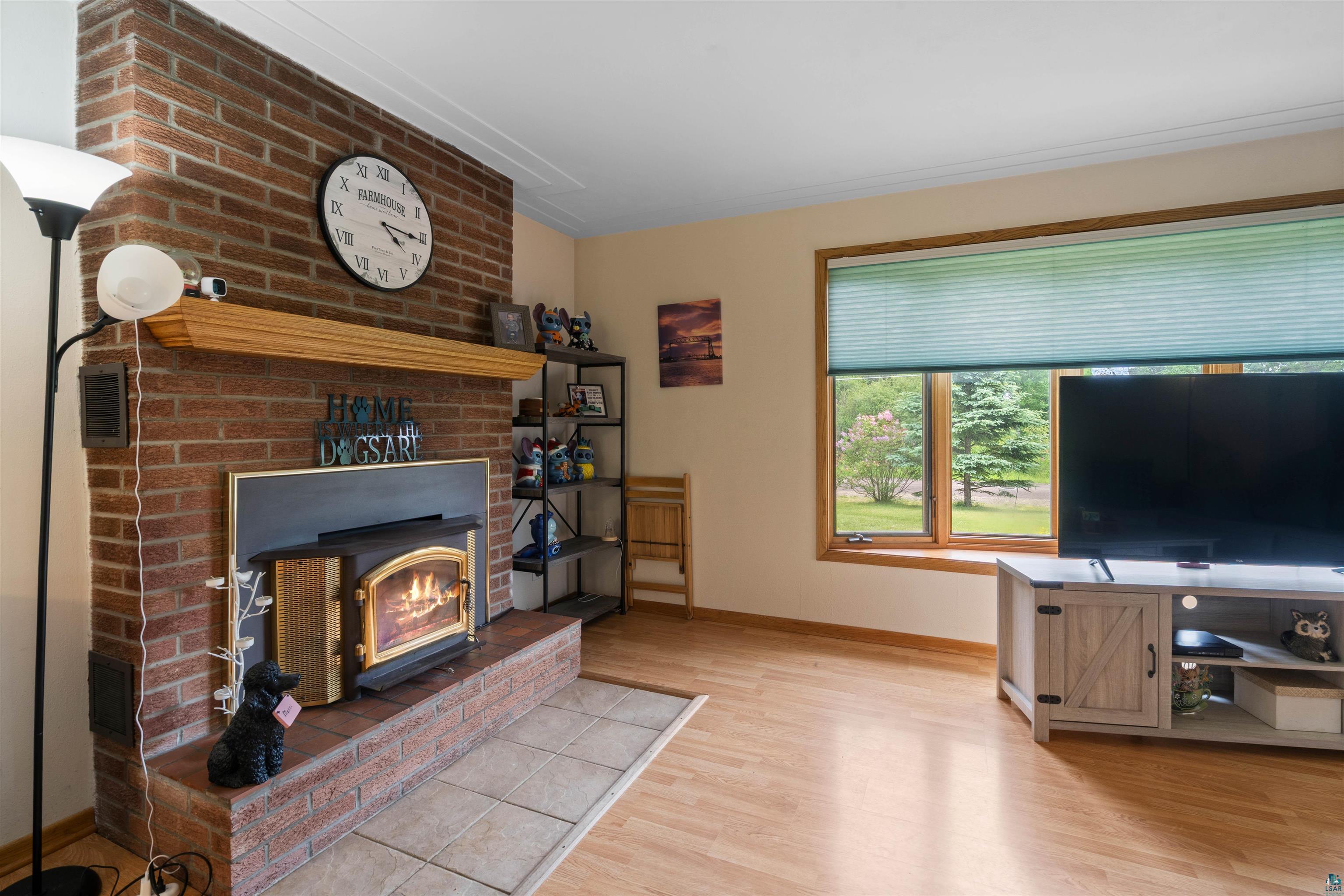 3711 Getchell Road Hermantown, MN 55811 - Photo 6 of 31 Brick fireplace with wood-burning insert and a natural wood mantle