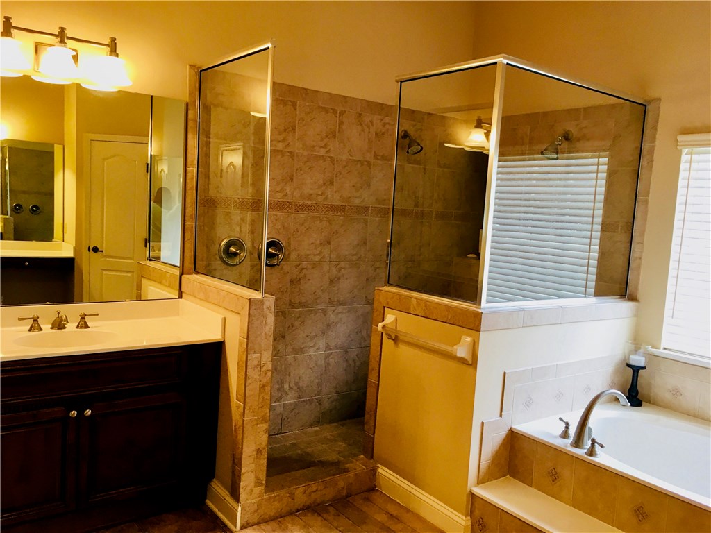 96525 Chester Road Yulee, FL 32097 - Photo 15 of 35 a bathroom with a sink and mirror with bathtub