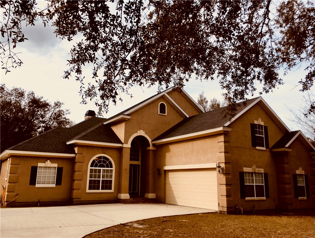 96525 Chester Road Yulee, FL 32097 - Photo 2 of 35 a view of a large white house with large windows