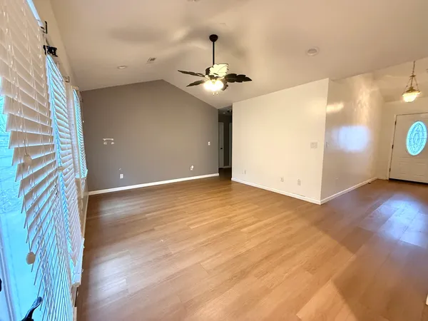 a view of empty room with wooden floor