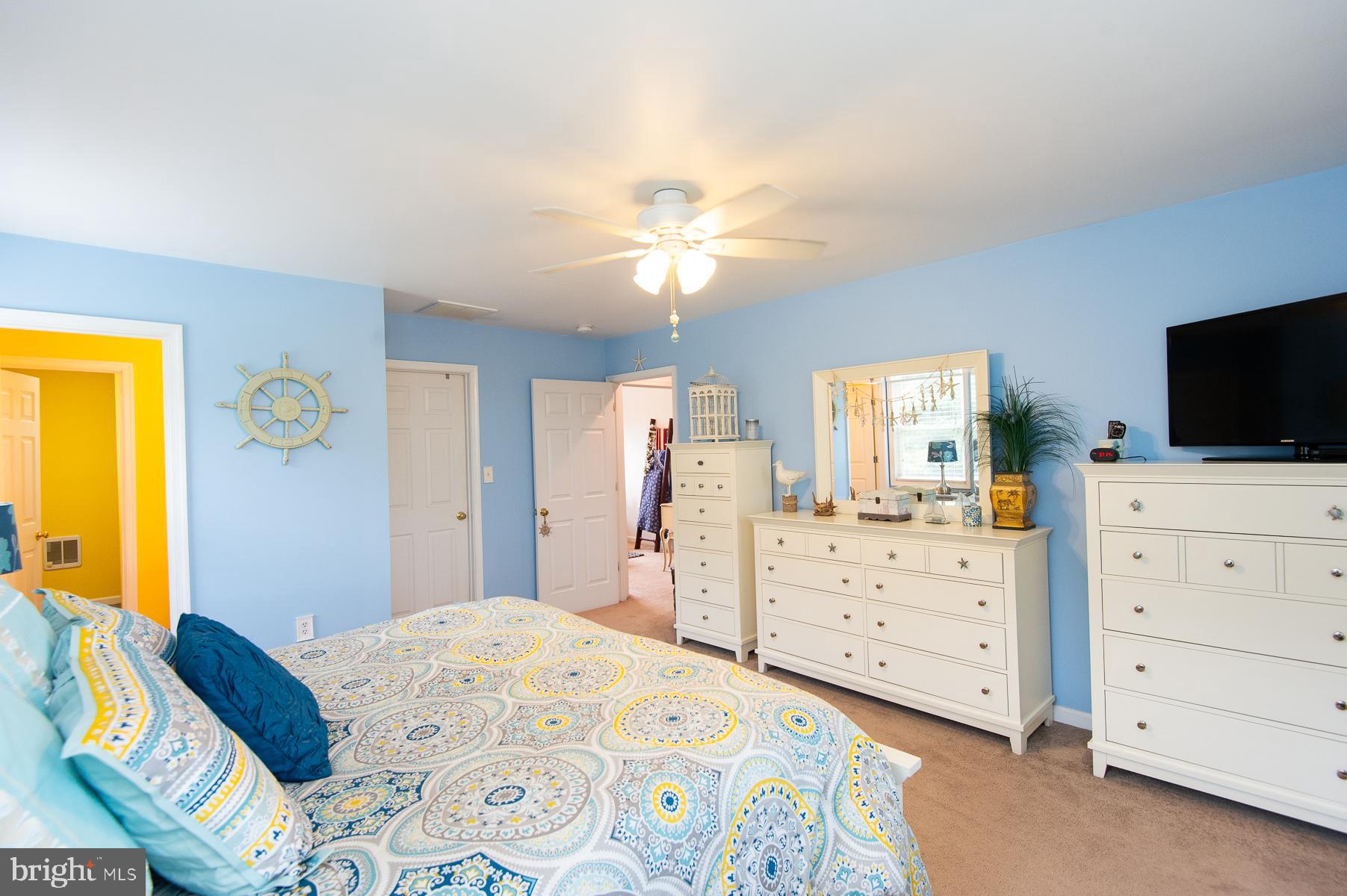 12136 Holly Road Ridgely, MD 21660 - Photo 32 of 136 a bedroom with a bed and a flat tv screen on dresser