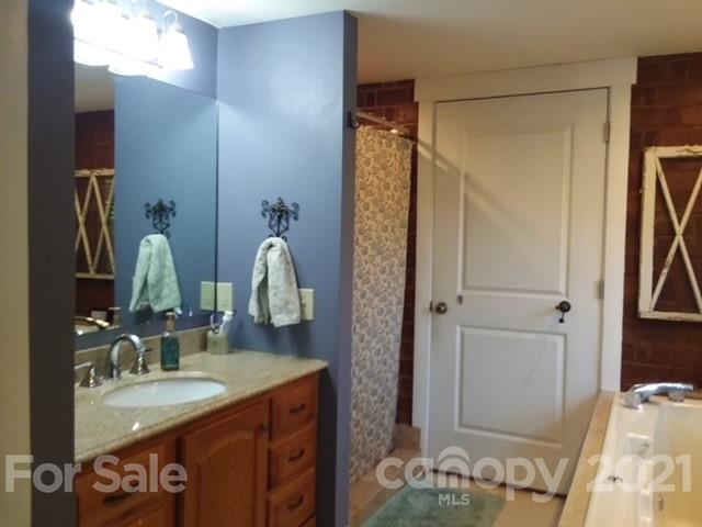 55 Hunter Bridge Road Stony Point, NC 28678 - Photo 17 of 32 a bathroom with a granite countertop sink and a mirror