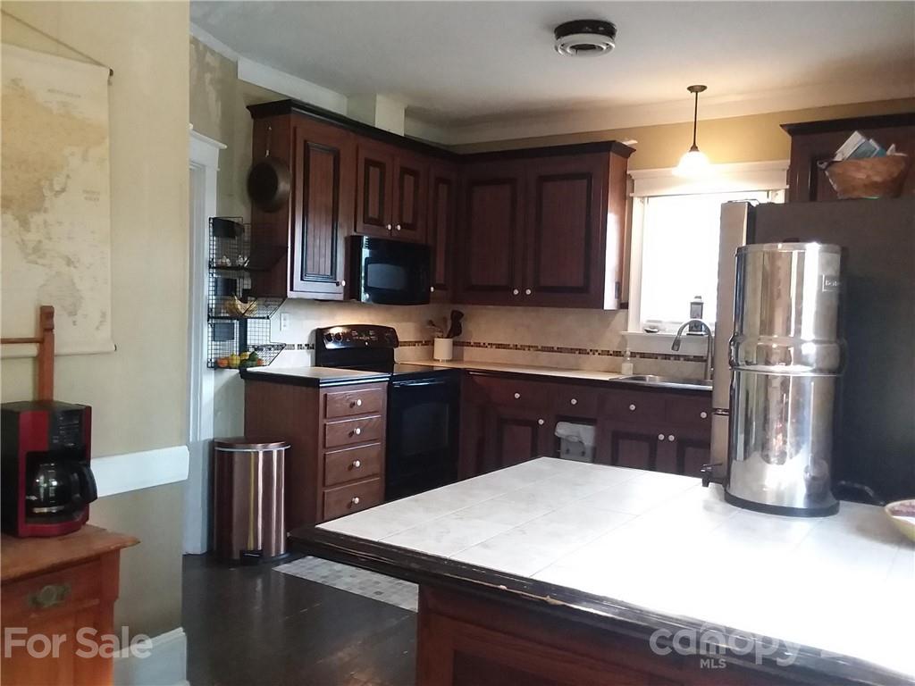 55 Hunter Bridge Road Stony Point, NC 28678 - Photo 29 of 32 a kitchen with stainless steel appliances granite countertop a refrigerator a stove a sink dishwasher and wooden cabinets with wooden floor