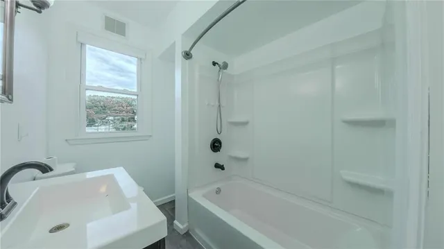 a bathroom with a tub sink and mirror