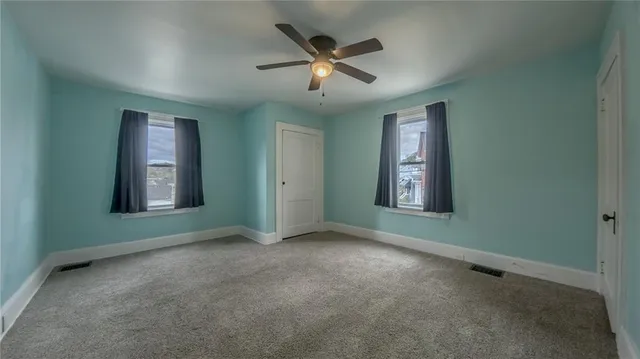 an empty room with closet and windows