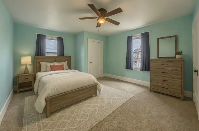 a spacious bedroom with a bed and a dresser