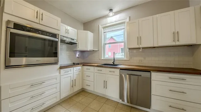 a kitchen with granite countertop white cabinets stainless steel appliances and sink