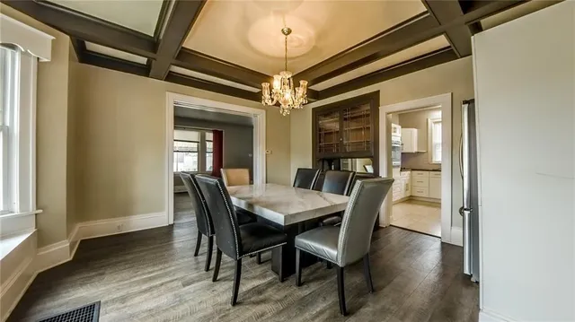 a dining room with furniture a chandelier and wooden floor