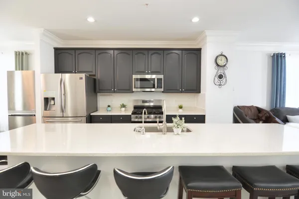 a kitchen with granite countertop a sink a stove and cabinets