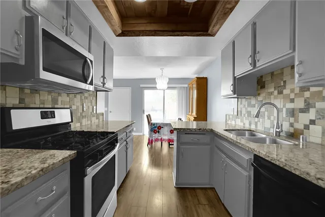 a kitchen with stainless steel appliances granite countertop a sink and stove top oven