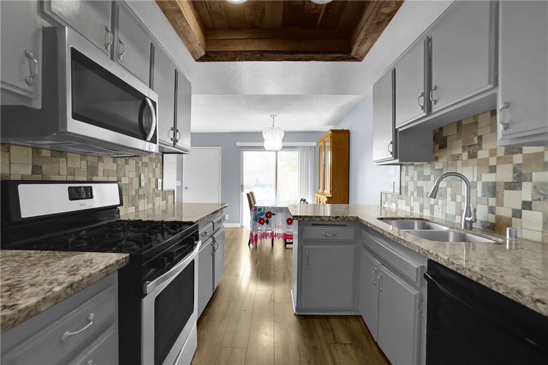 a kitchen with stainless steel appliances granite countertop a sink and stove top oven