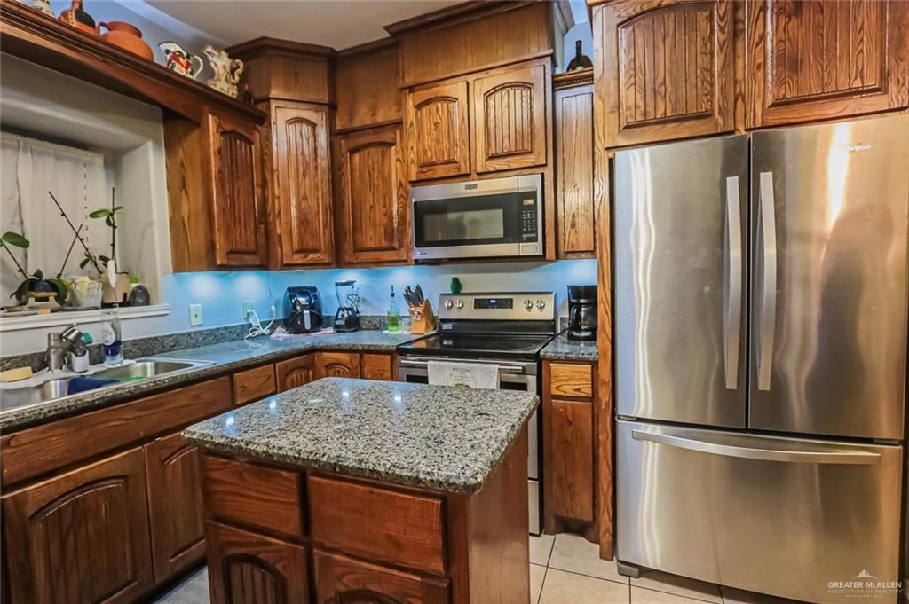 4701 Russell Circle Mission, TX 78574 - Photo 10 of 37 a kitchen with stainless steel appliances granite countertop a refrigerator a stove a sink and a microwave